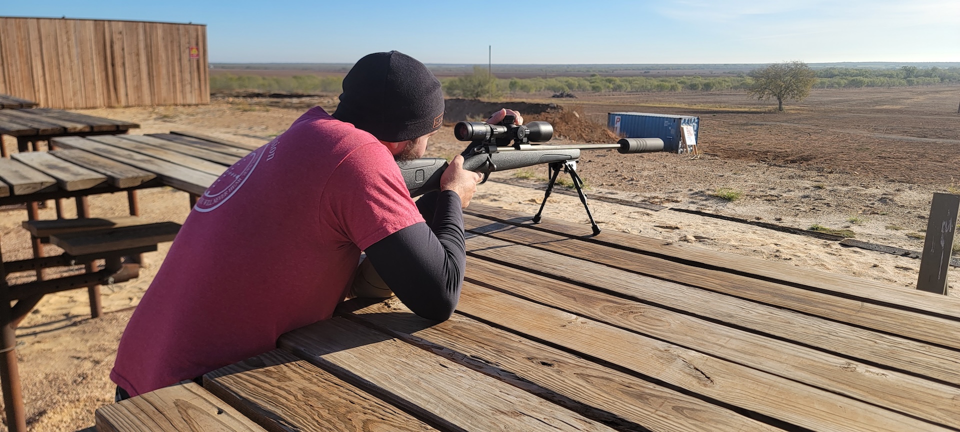 man shooting rifle with suppressor