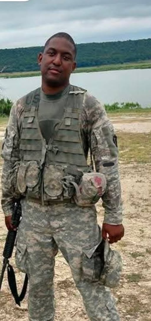 jovan_jackson in camo standing near water.